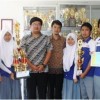 Kepala Sekolah SMK Pertiwi berfoto bersama dengan siswanya yang berprestasi.